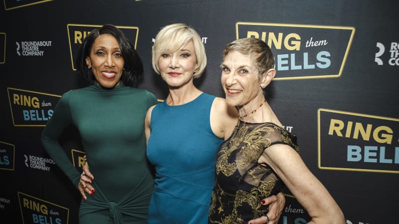A group of people in formal attire pose on the red carpet.